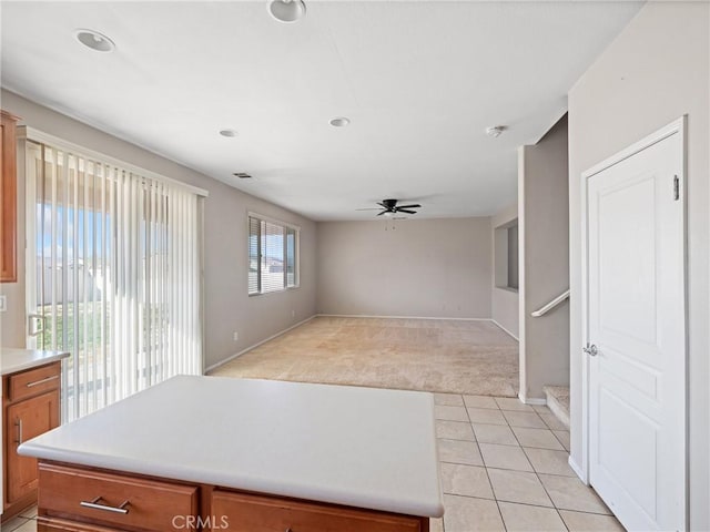 kitchen with ceiling fan and light carpet