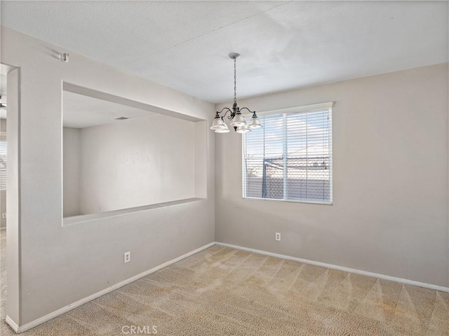 carpeted empty room with a chandelier