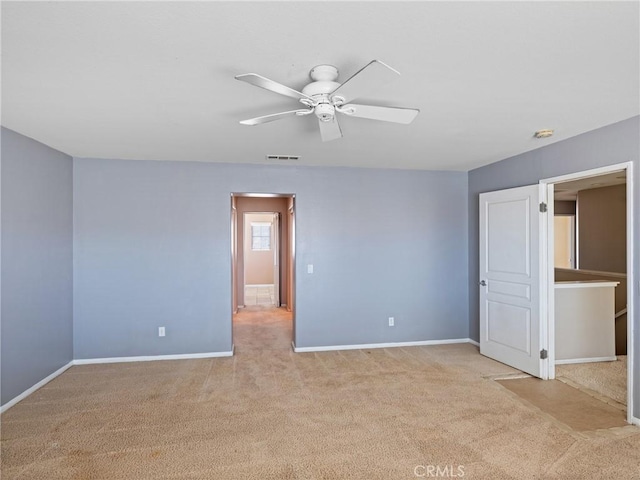 spare room featuring ceiling fan and light colored carpet