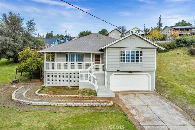 view of front of property with a front lawn, covered porch, and a garage