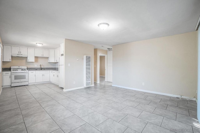 kitchen with white appliances, white cabinetry, light tile patterned flooring, and sink