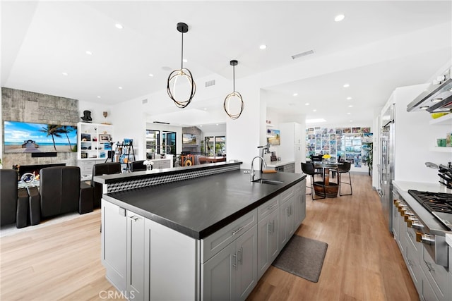 17 Monaco, Newport Beach, CA 92660 - kitchen with open floor plan, a sink, dark countertops, appliances with stainless steel finishes, and light wood-type flooring