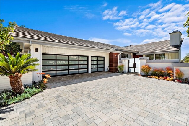 17 Monaco, Newport Beach, CA 92660 - view of front of property featuring a fenced front yard, an attached garage, a gate, decorative driveway, and a tiled roof