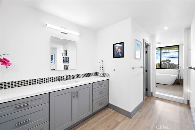 17 Monaco, Newport Beach, CA 92660 - full bathroom with vanity, wood finished floors, baseboards, a soaking tub, and recessed lighting