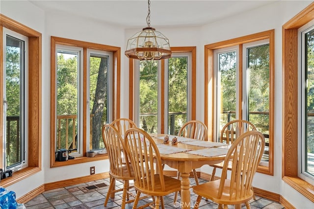 sunroom / solarium with a chandelier