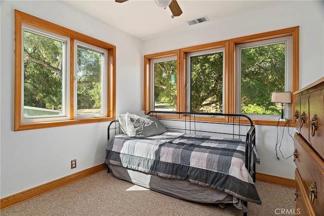 carpeted bedroom with ceiling fan and multiple windows