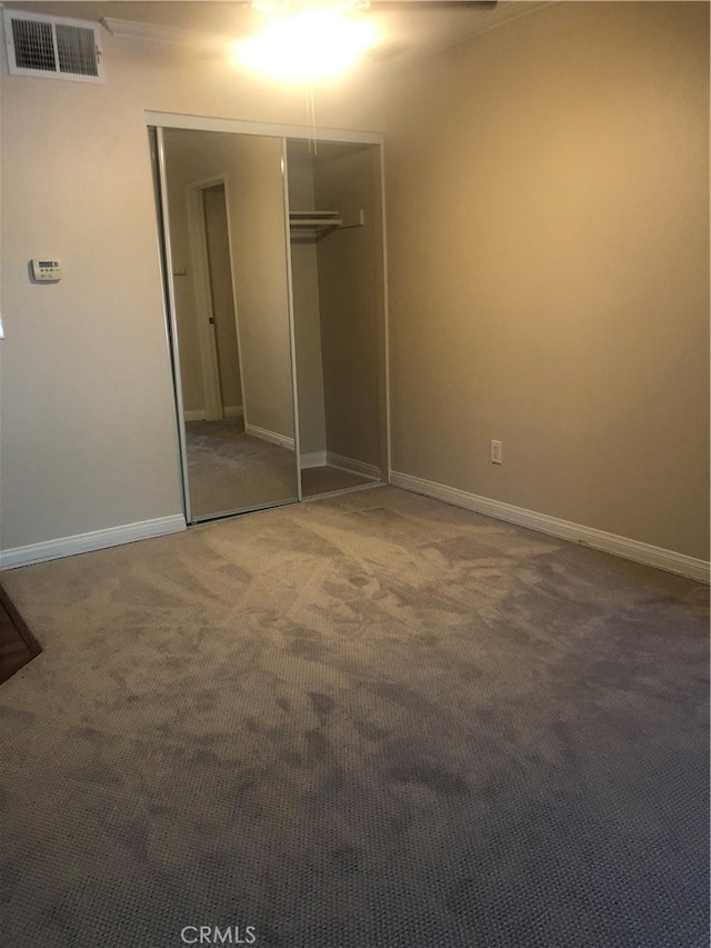 unfurnished bedroom with carpet floors and a closet