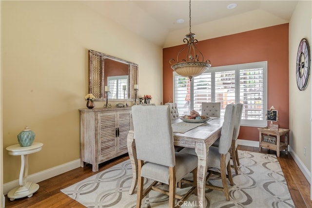 dining area featuring lofted ceiling and hardwood / wood-style flooring