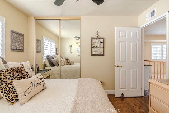 bedroom with a closet, ceiling fan, and dark hardwood / wood-style flooring