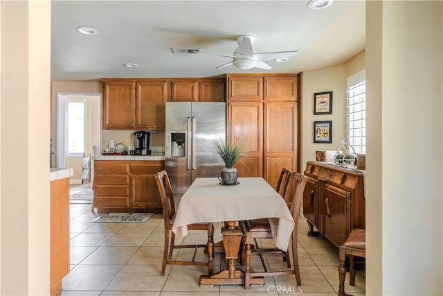 kitchen featuring high end refrigerator, light tile patterned floors, and ceiling fan