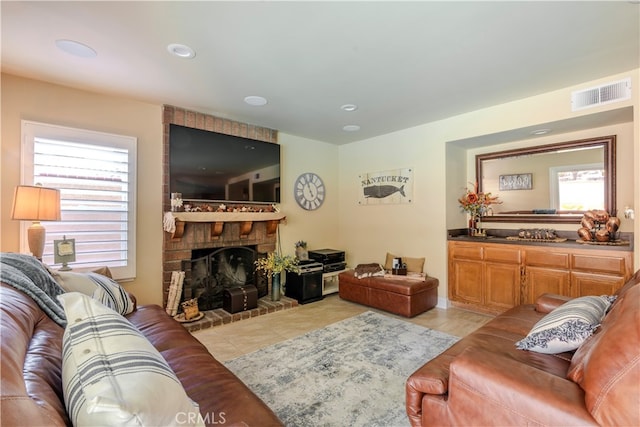 living room with a fireplace and light tile patterned floors