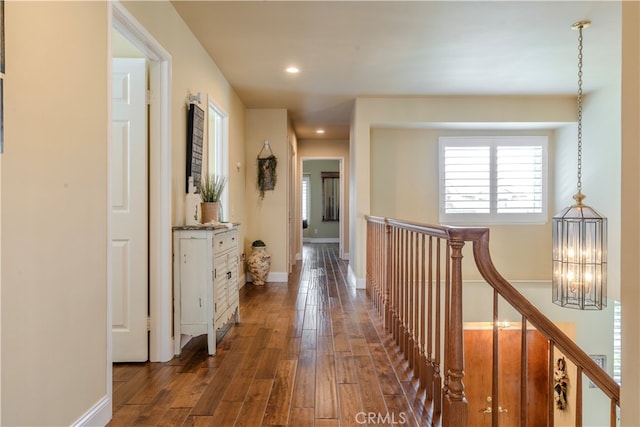 hall with a notable chandelier and dark hardwood / wood-style floors