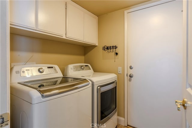 washroom featuring separate washer and dryer and cabinets