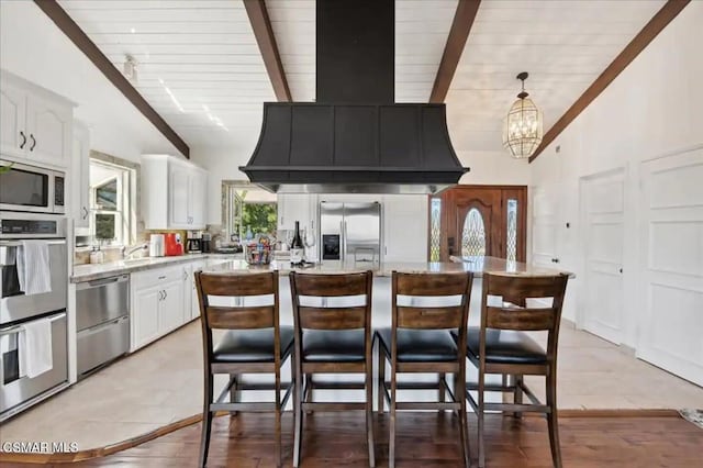 kitchen featuring a kitchen island, wooden ceiling, stainless steel appliances, and white cabinets