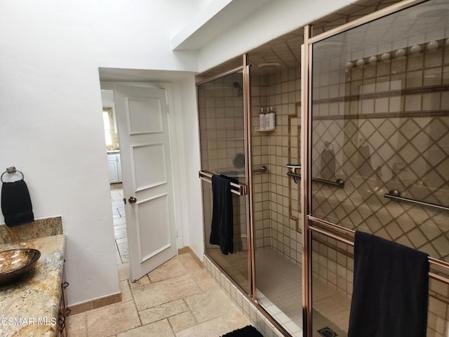 bathroom with vanity and a shower with door