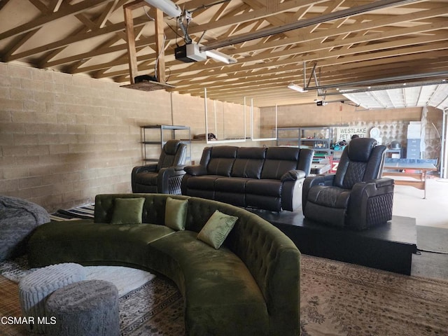 cinema room featuring vaulted ceiling and concrete floors