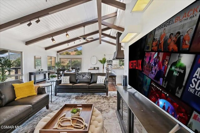 living room with ceiling fan, lofted ceiling with beams, and a wealth of natural light