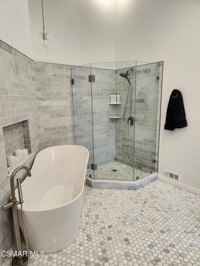 bathroom featuring tile patterned flooring and separate shower and tub