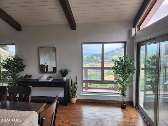 dining room with beamed ceiling, hardwood / wood-style floors, and a mountain view