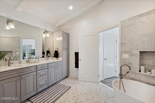 bathroom with tile patterned flooring, a washtub, and vanity