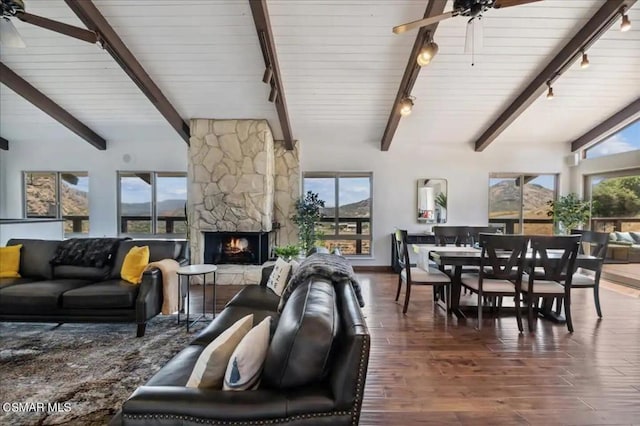 living room featuring beamed ceiling, ceiling fan, high vaulted ceiling, dark hardwood / wood-style floors, and a fireplace