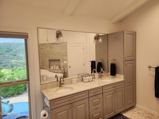 bathroom with beam ceiling, a wealth of natural light, and vanity