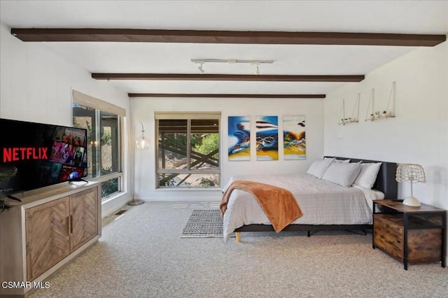 bedroom featuring beamed ceiling and light colored carpet