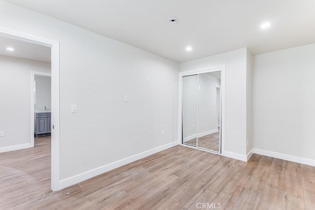 unfurnished bedroom with a closet and light hardwood / wood-style flooring