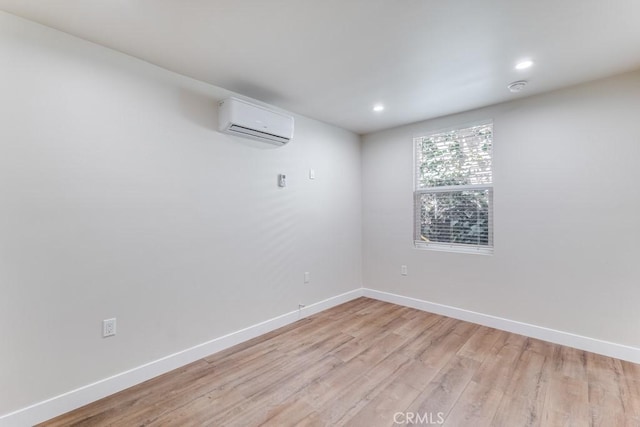 unfurnished room featuring light hardwood / wood-style flooring and a wall mounted AC