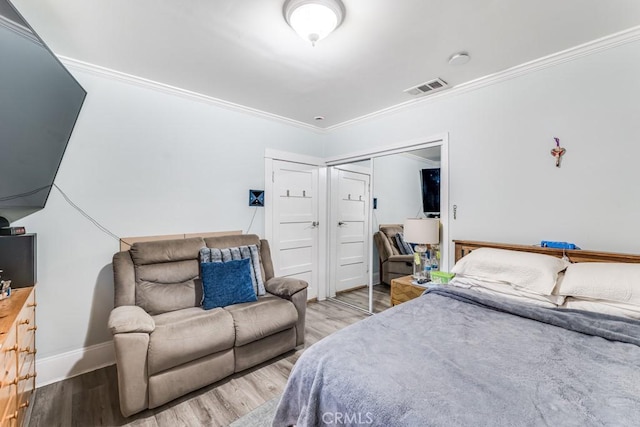 bedroom with crown molding, a closet, and light hardwood / wood-style floors