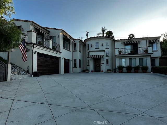 view of front of home with a garage and a balcony