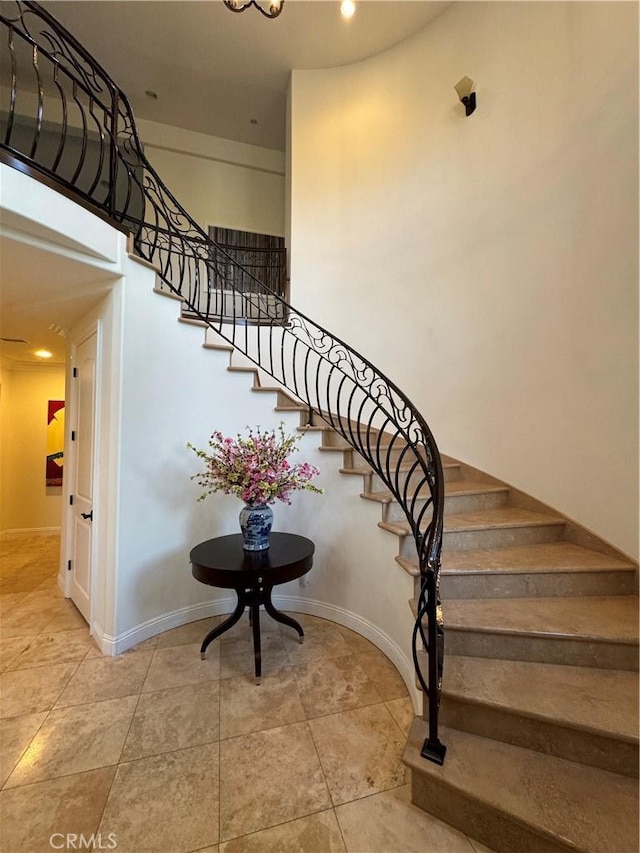 stairway featuring a towering ceiling