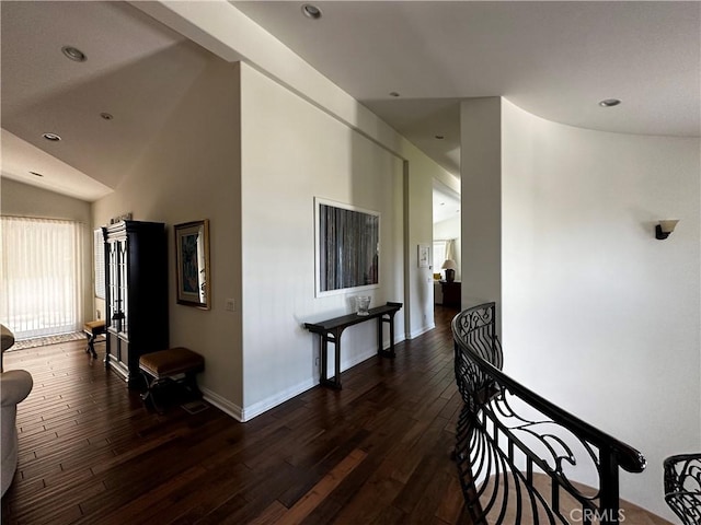 corridor featuring dark wood-type flooring and lofted ceiling