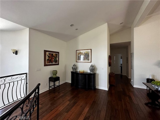 hall with vaulted ceiling and dark hardwood / wood-style flooring