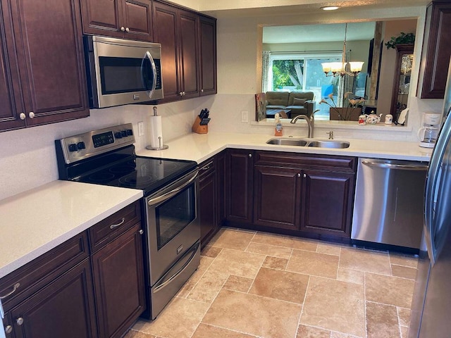 kitchen featuring hanging light fixtures, sink, appliances with stainless steel finishes, a notable chandelier, and dark brown cabinetry