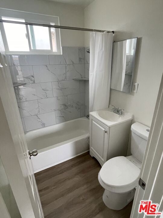 full bathroom featuring vanity, toilet, wood-type flooring, and shower / tub combo