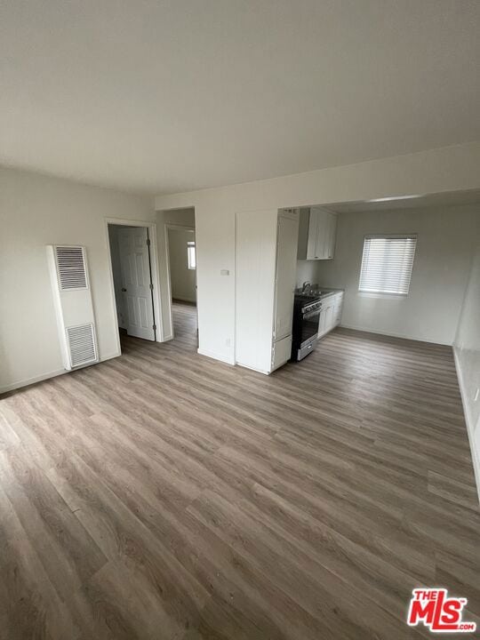 unfurnished living room with dark wood-type flooring