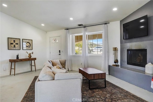 living room with lofted ceiling and concrete floors