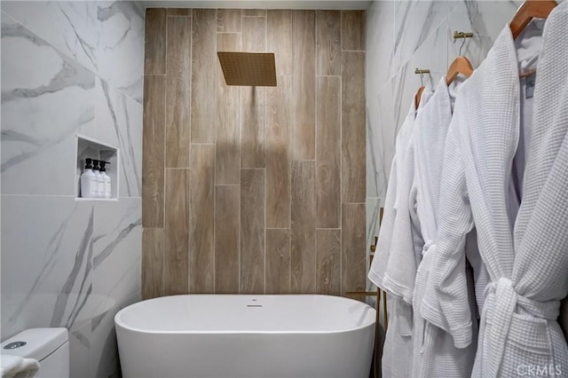 bathroom featuring separate shower and tub, toilet, and tile walls