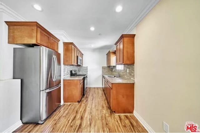 kitchen with decorative backsplash, stainless steel appliances, light hardwood / wood-style flooring, ornamental molding, and sink