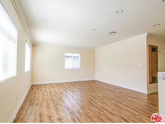 empty room featuring crown molding and light hardwood / wood-style floors