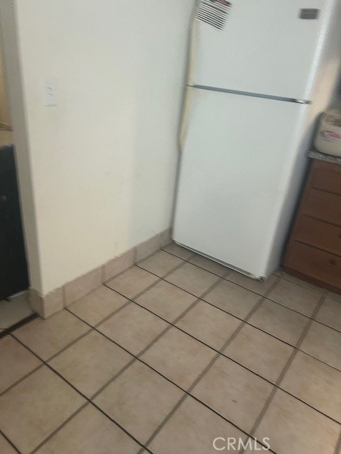 interior space with white refrigerator and tile floors