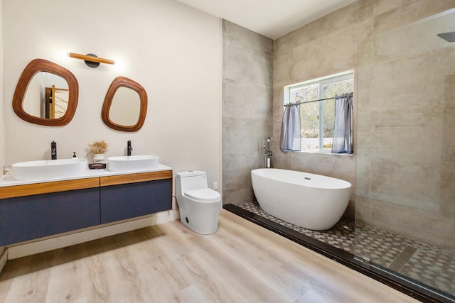 full bathroom with wood-type flooring, independent shower and bath, vanity, and toilet