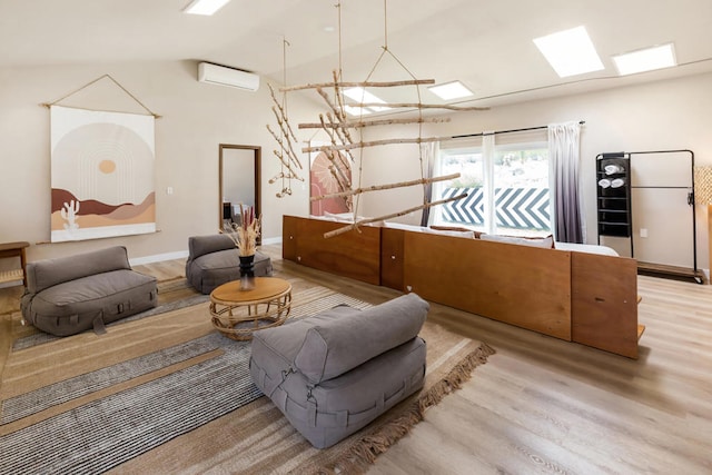 interior space featuring light wood-type flooring, lofted ceiling, and an AC wall unit