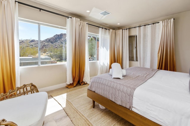 bedroom with a mountain view and light wood-type flooring