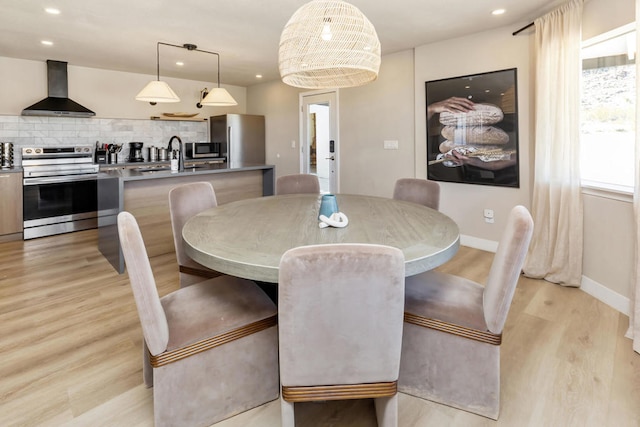 dining area featuring sink and light hardwood / wood-style flooring