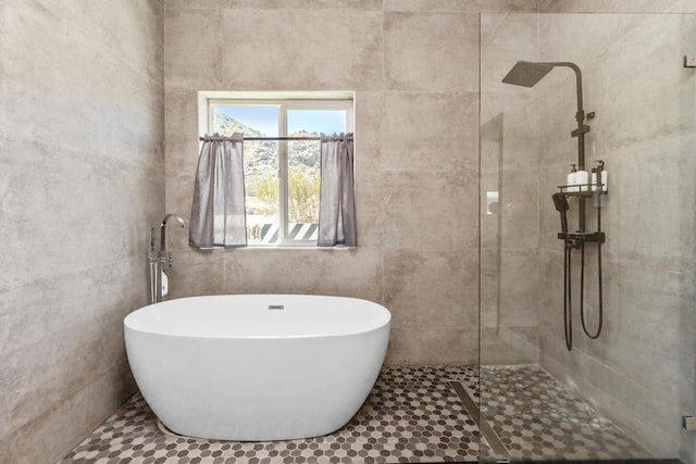 bathroom with tile walls, tile patterned flooring, and separate shower and tub