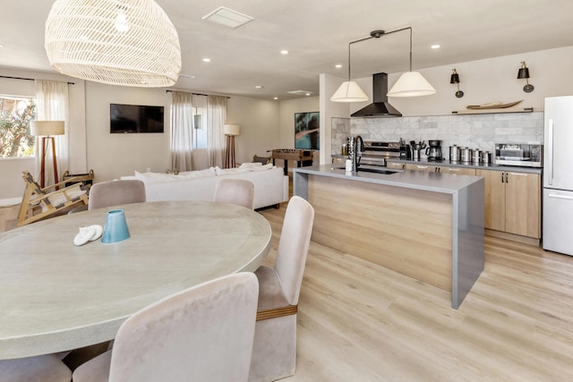 dining area with light wood-type flooring and sink