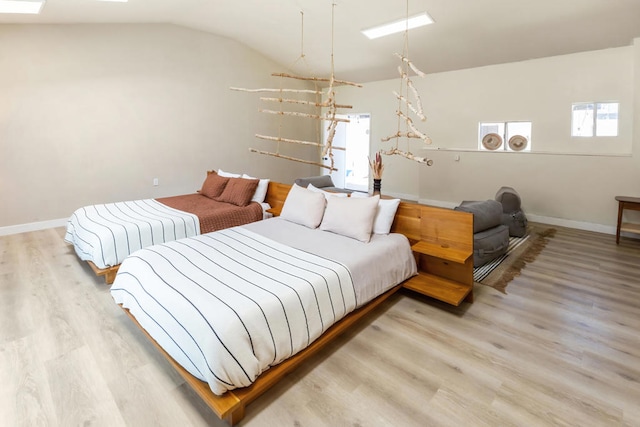 bedroom with light hardwood / wood-style flooring and vaulted ceiling