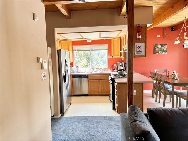 2005 Zermatt Dr, Pine Mountain Club, CA 93222 - kitchen featuring appliances with stainless steel finishes, light countertops, light colored carpet, open floor plan, and a wood ceiling with exposed beams